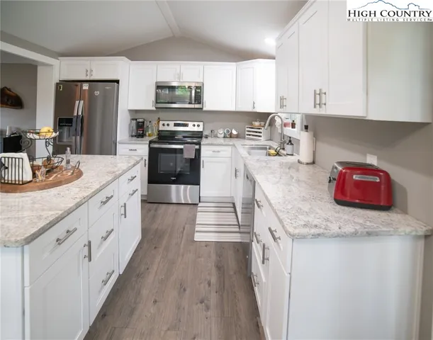 a kitchen with stainless steel appliances granite countertop a stove a sink dishwasher and a refrigerator