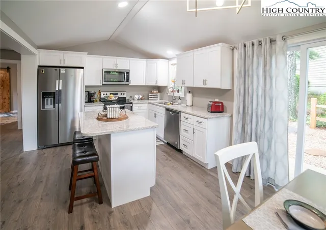 a kitchen with stainless steel appliances a stove refrigerator sink and cabinets