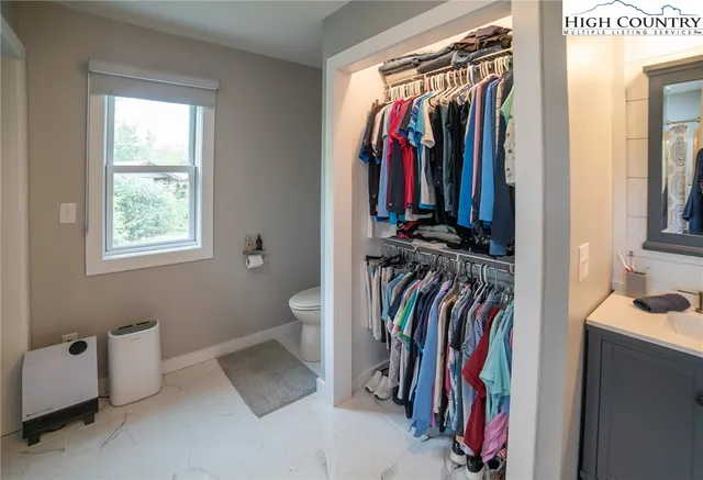 a view of walk in closet with clothes and shoes