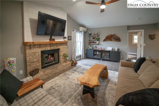 a living room with furniture a flat screen tv and a fireplace