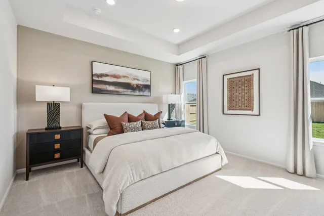 a bedroom with a bed and a lamp on dresser