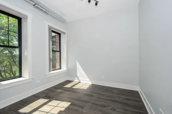 a view of a livingroom with wooden floor and a window