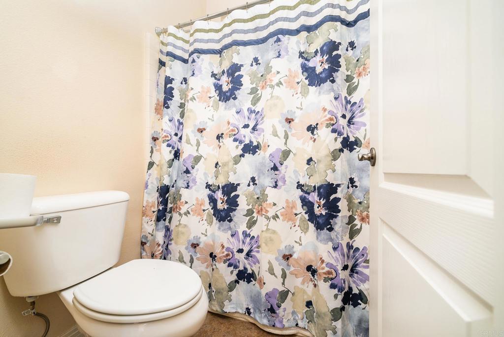 1075 Crimson Drive San Marcos, CA 92069 - Photo 22 of 74 a white toilet sitting next to a shower curtain