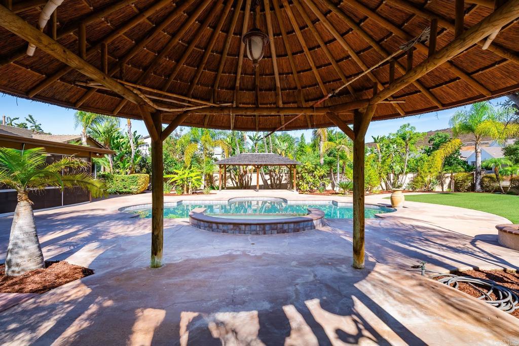 1075 Crimson Drive San Marcos, CA 92069 - Photo 52 of 74 a view of a backyard with table and chairs under an umbrella with a small yard