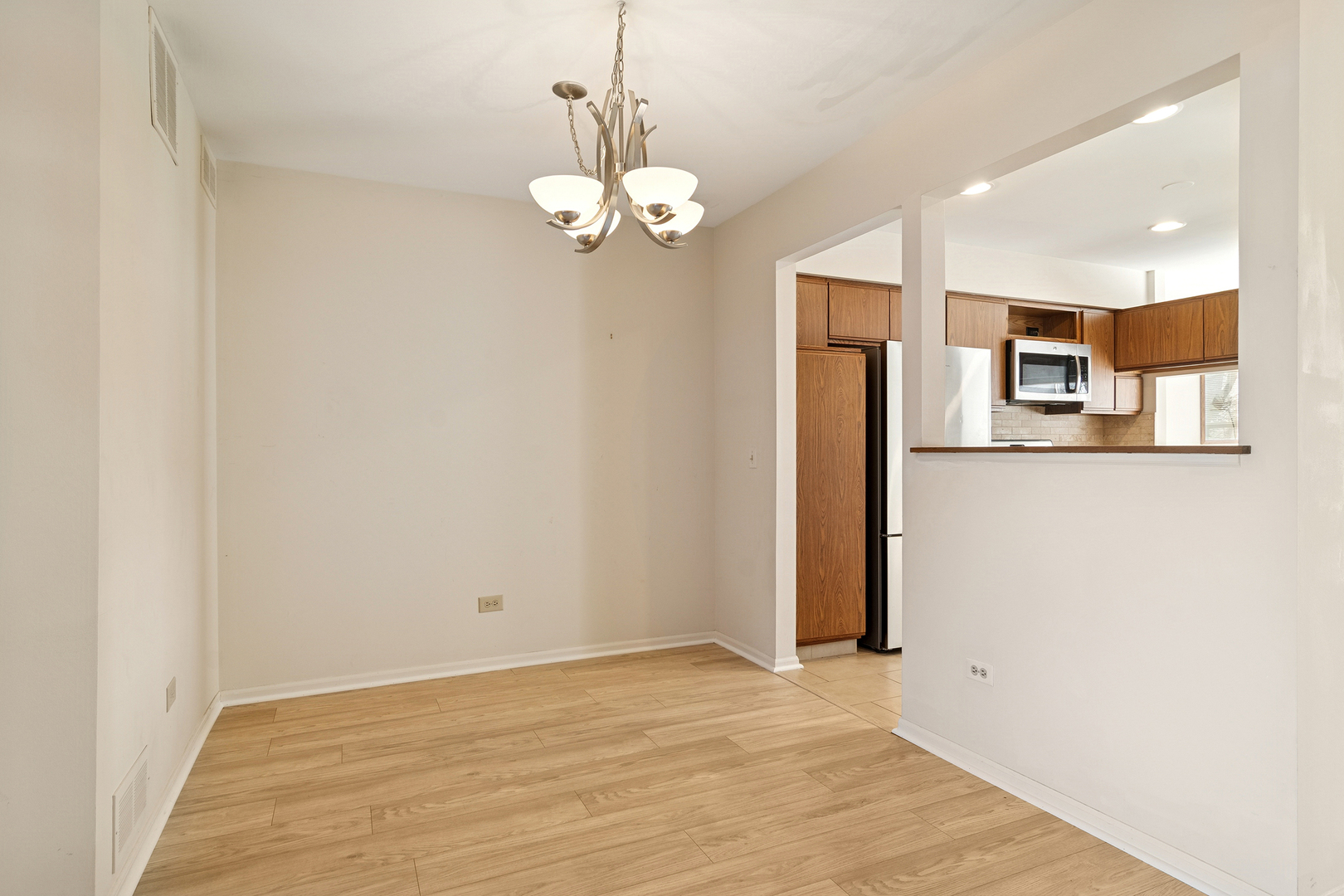 988 Ridgefield Lane Wheeling, IL 60090 - Photo 3 of 18 a view of a kitchen with a refrigerator a ceiling fan and wooden floor