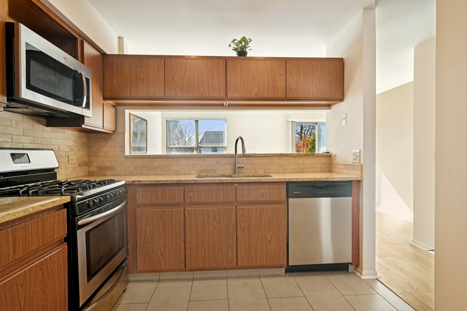 988 Ridgefield Lane Wheeling, IL 60090 - Photo 5 of 18 a kitchen with stainless steel appliances granite countertop a sink and a stove