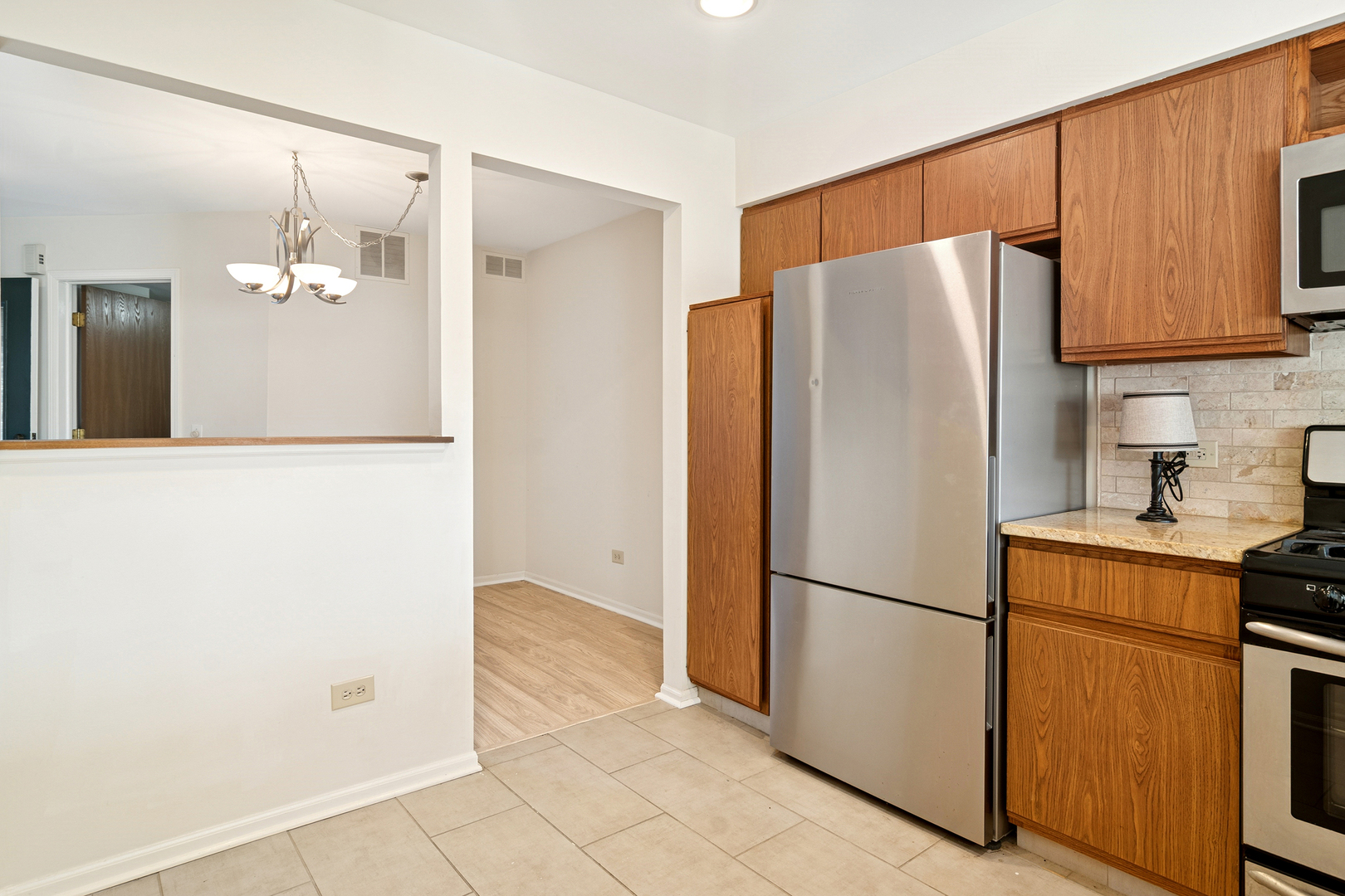 988 Ridgefield Lane Wheeling, IL 60090 - Photo 7 of 18 a white refrigerator freezer sitting in a kitchen