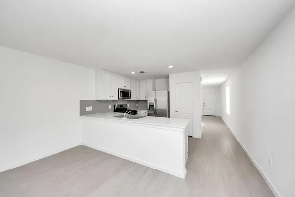 a view of kitchen with stainless steel appliances a refrigerator and a counter top space