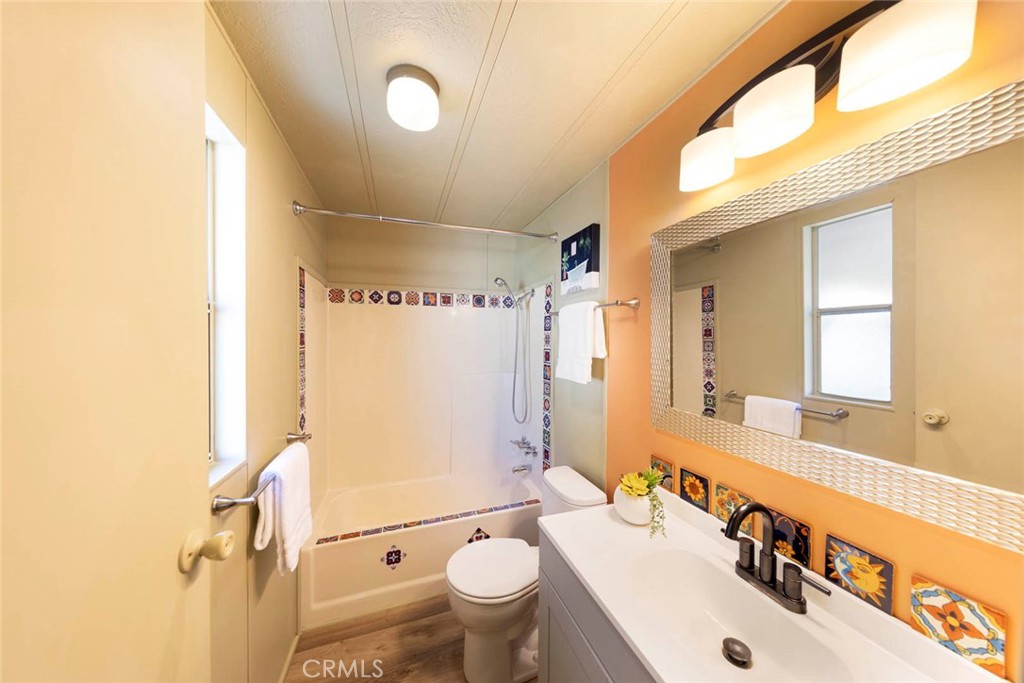32802 Valle Road, Unit 108 San Juan Capistrano, CA 92675 - Photo 11 of 32 a bathroom with a sink a toilet a mirror and shower