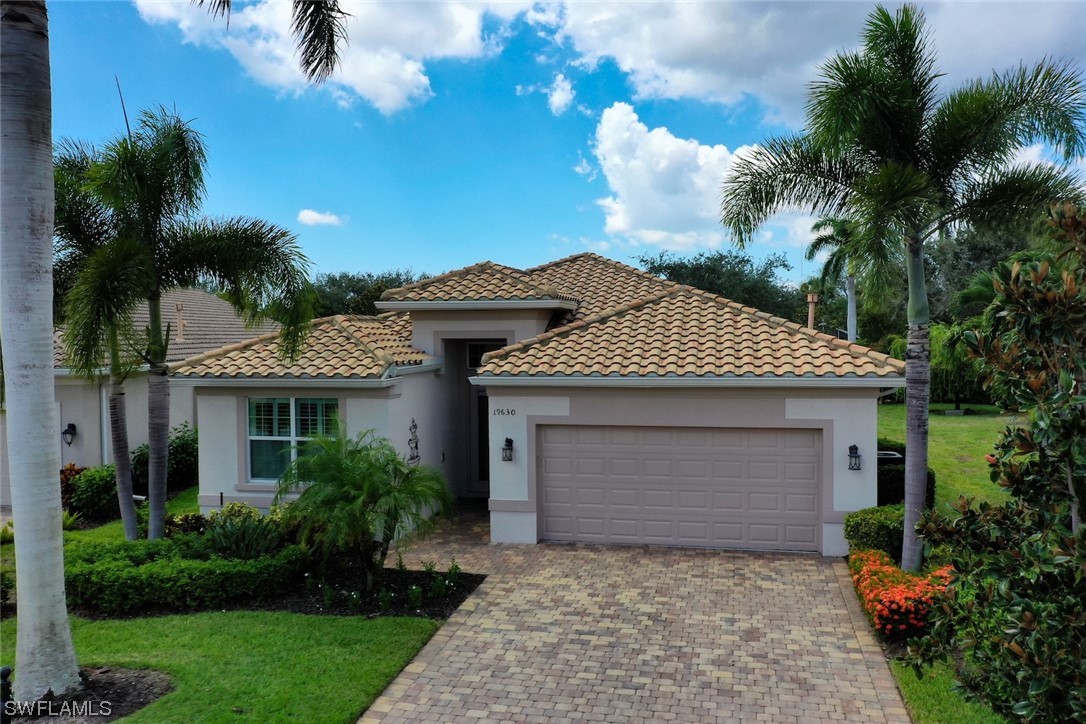 19630 Tesoro Way Estero, FL 33967 - Photo 1 of 44 a front view of a house with a garden