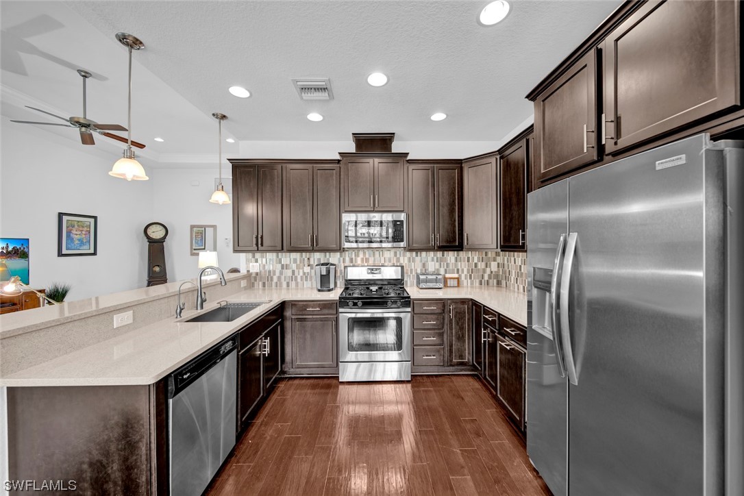 19630 Tesoro Way Estero, FL 33967 - Photo 11 of 44 a kitchen with stainless steel appliances granite countertop a sink a stove and a refrigerator