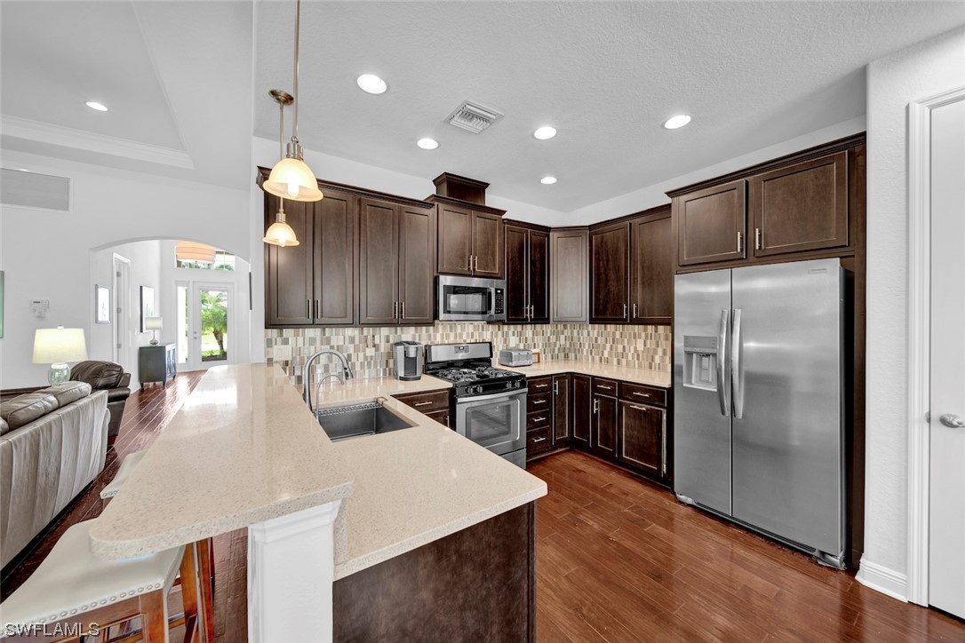 19630 Tesoro Way Estero, FL 33967 - Photo 10 of 44 a large kitchen with sink a refrigerator and a stove top oven