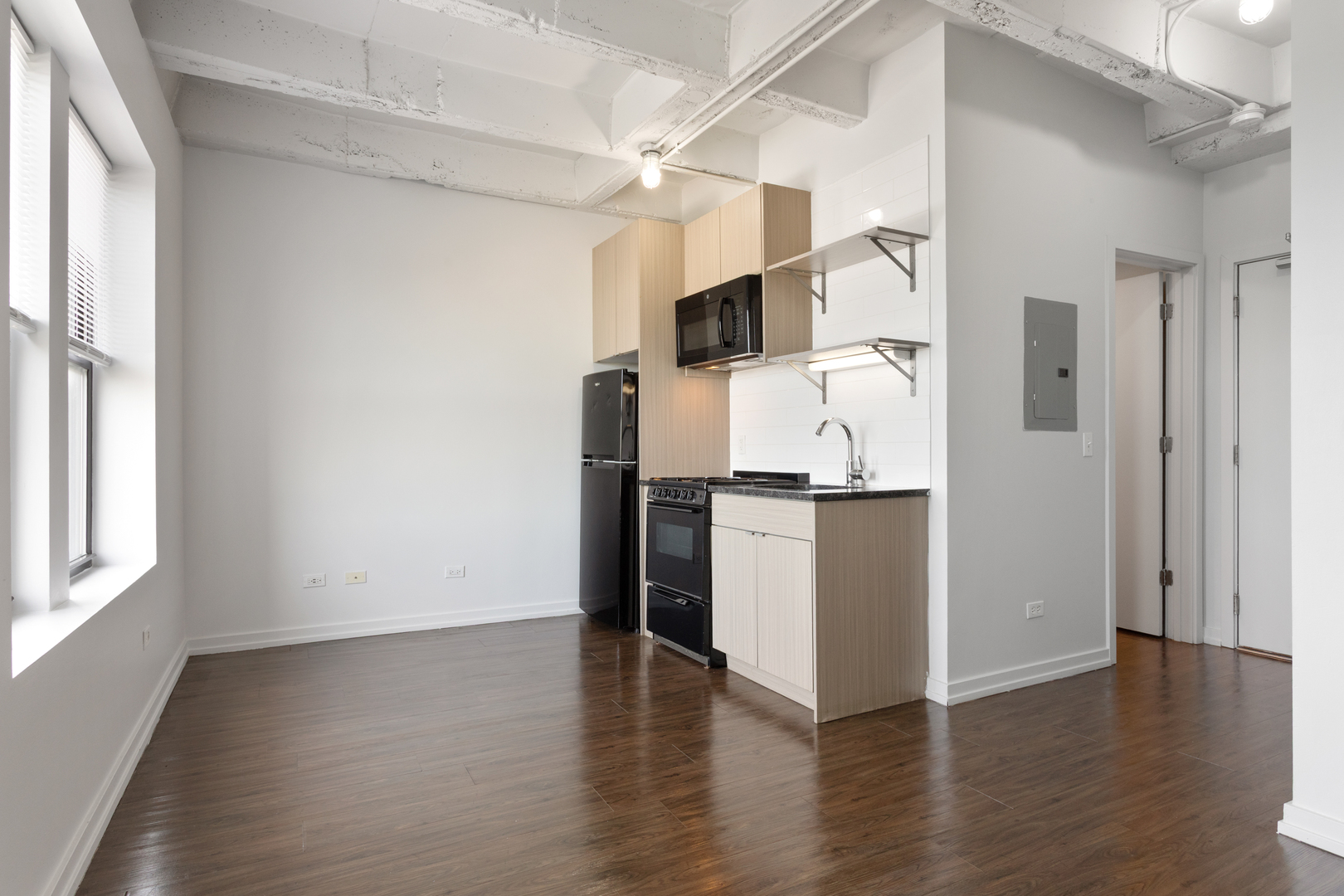 1325 West Wilson Avenue, Unit 907 Chicago, IL 60640 - Photo 3 of 19 an empty room with wooden floor and windows