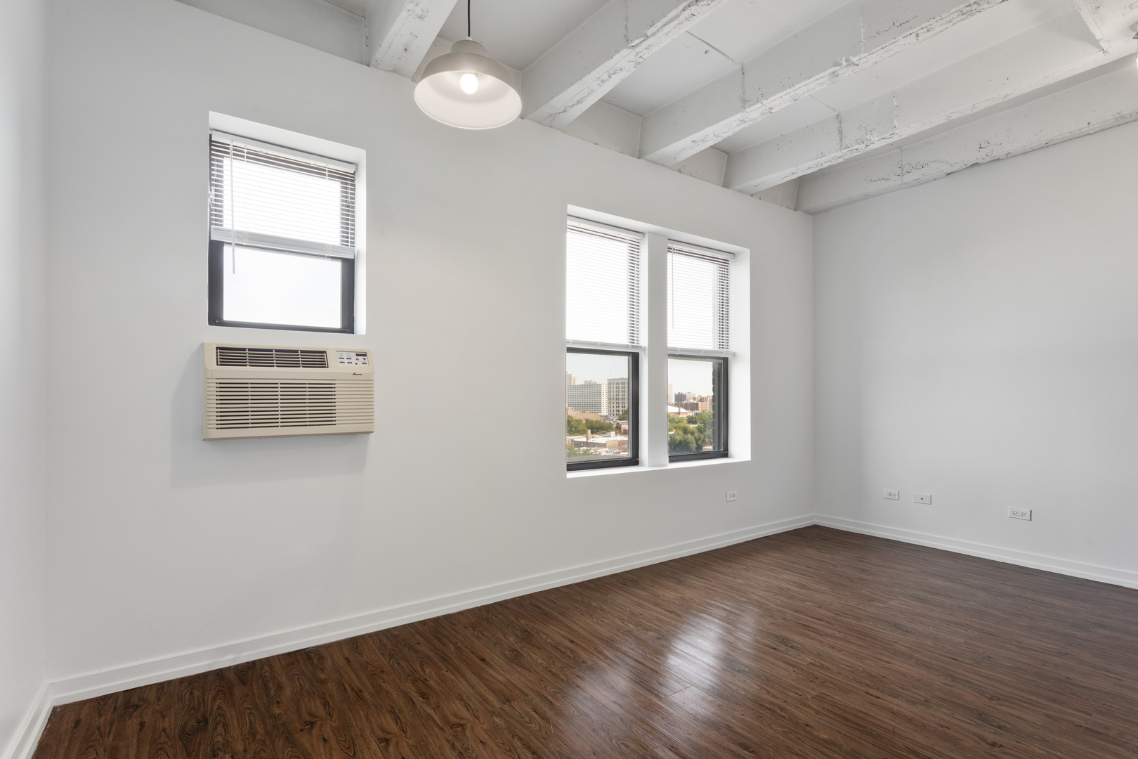 1325 West Wilson Avenue, Unit 907 Chicago, IL 60640 - Photo 6 of 19 an empty room with wooden floor and windows