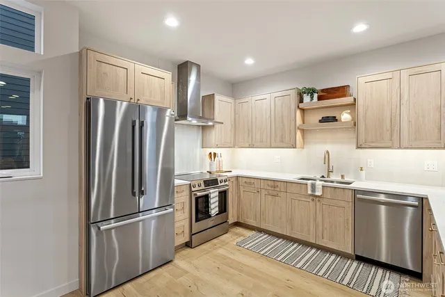 a kitchen with stainless steel appliances granite countertop a refrigerator sink and stove