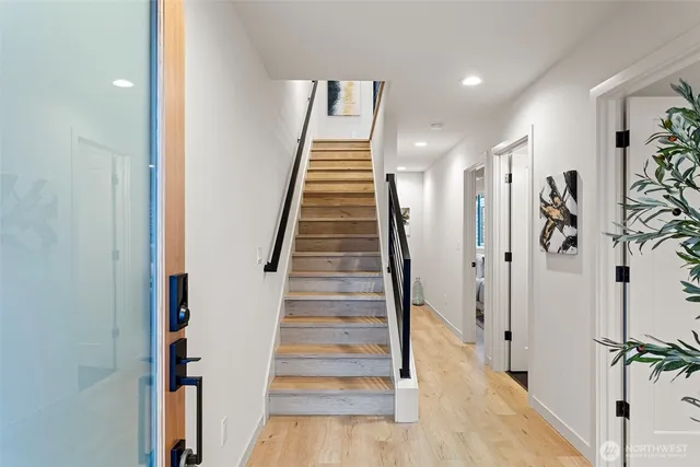 a view of a hallway with wooden floor and entryway