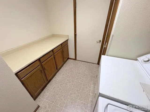 a utility room with cabinets washer and dryer