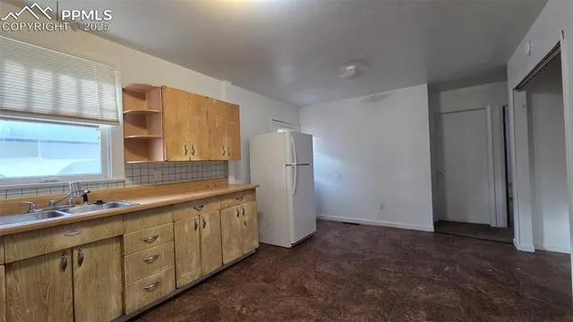 a kitchen with white cabinets and refrigerator