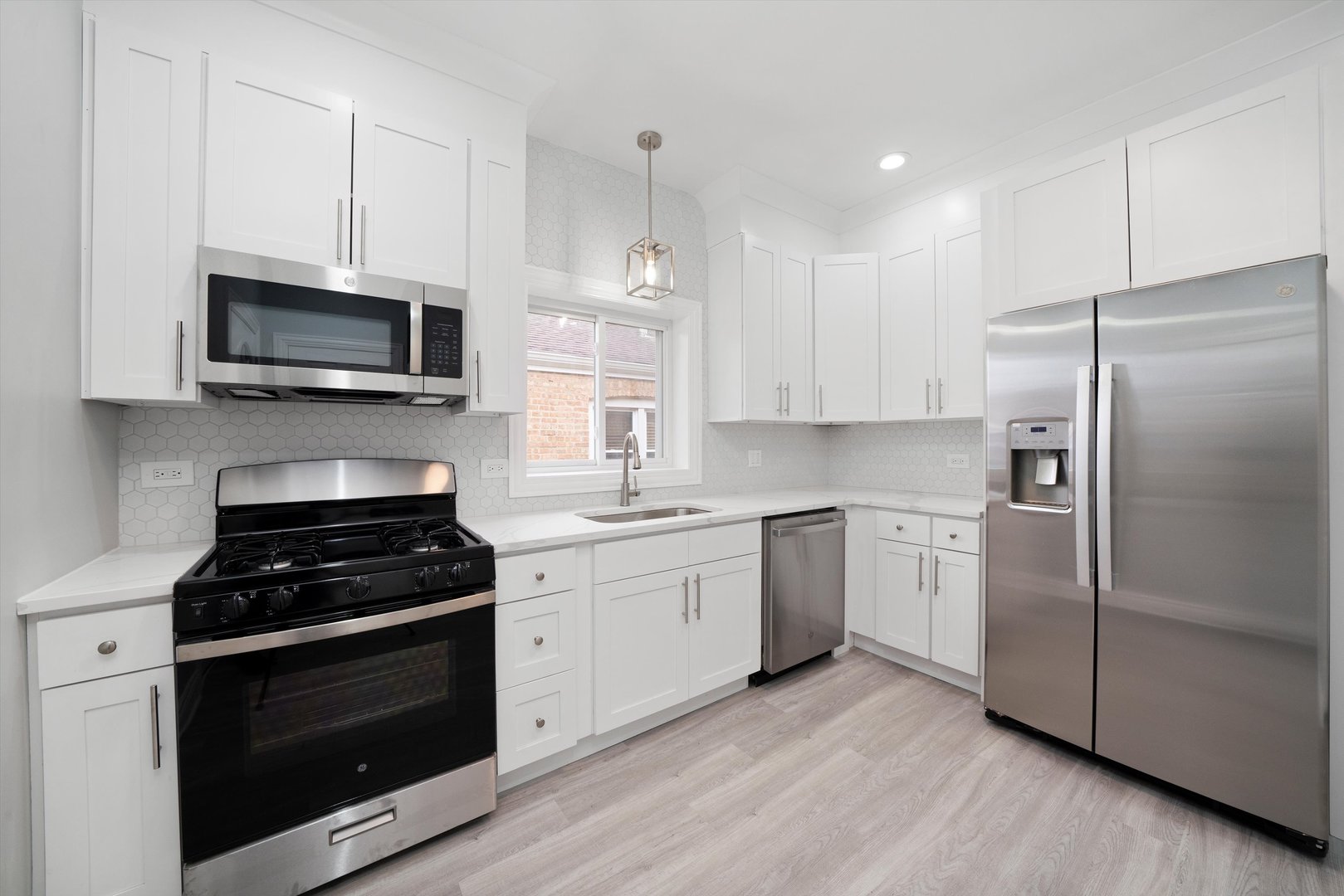 5237 Long Avenue Chicago, IL 60638 - Photo 11 of 41 a kitchen with granite countertop a stove a microwave a refrigerator a sink and cabinets