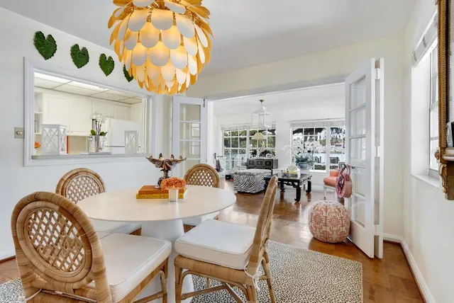 a living room with furniture kitchen view and a chandelier