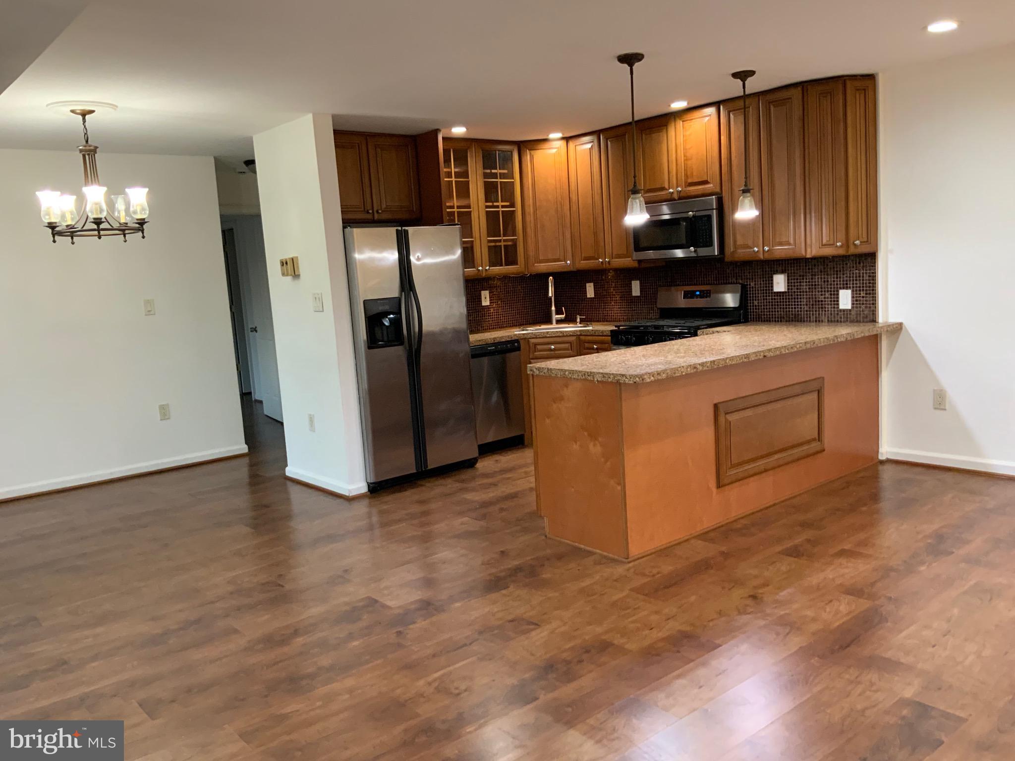 3744 Bel Pre Road, Unit 10 Silver Spring, MD 20906 - Photo 5 of 23 a kitchen with stainless steel appliances a refrigerator a stove a microwave and island