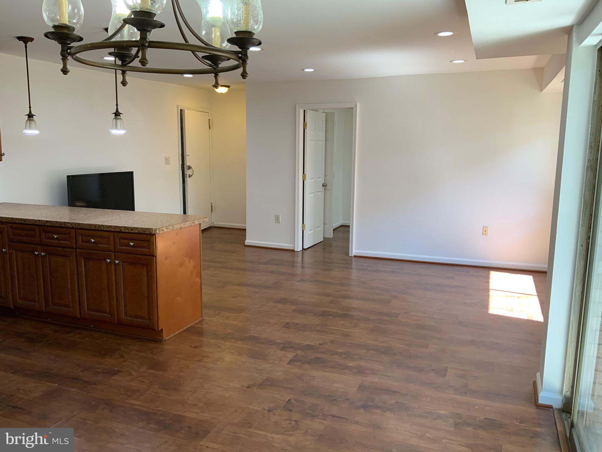 3744 Bel Pre Road, Unit 10 Silver Spring, MD 20906 - Photo 8 of 23 a kitchen with kitchen island a counter top space appliances and a ceiling fan