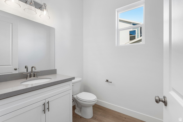 58 South Crimson Way, Unit 306 Mapleton, UT 84664 - Photo 6 of 24 Modern bathroom featuring a white vanity with shaker-style cabinetry, a gray countertop, an undermount sink with a brushed nickel faucet, and wood-finish flooring