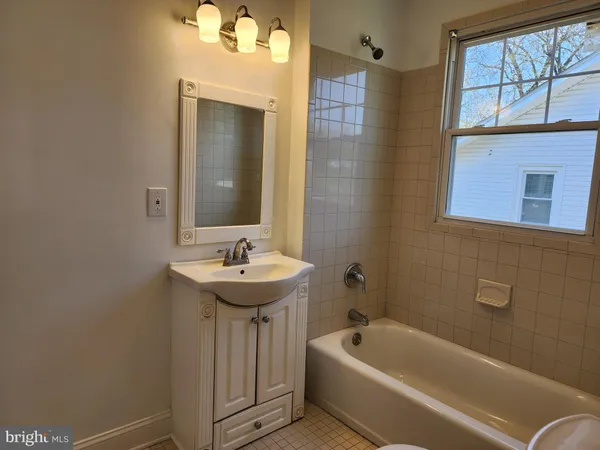 a bathroom with a sink a bathtub and a mirror