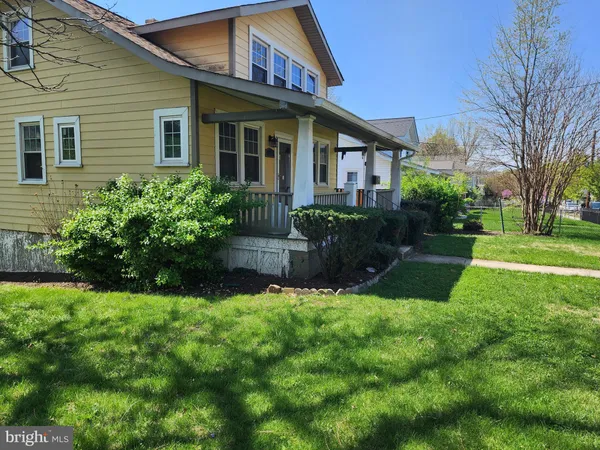 a view of a brick house with a yard and plants