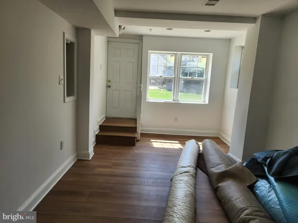 a view of a livingroom with wooden floor and a window