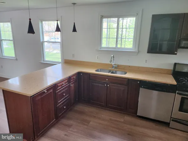 a kitchen with a sink cabinets wooden floor and a window