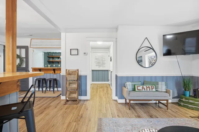 a kitchen with stainless steel appliances granite countertop a stove top oven a sink dishwasher a dining table and chairs with wooden floor