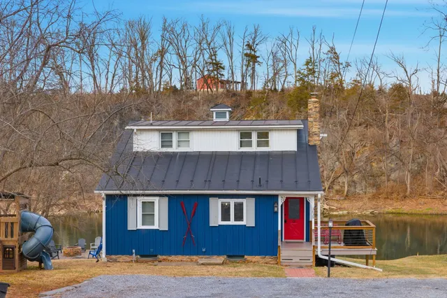 a view of a house with a big yard and large trees