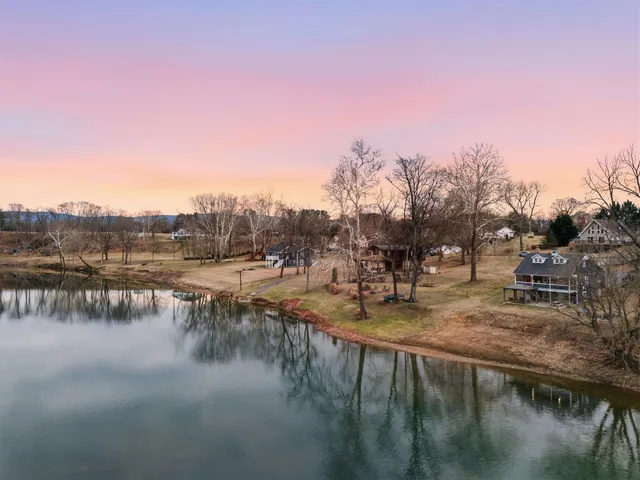 a dining room with wooden floor a chandelier a glass table and chairs