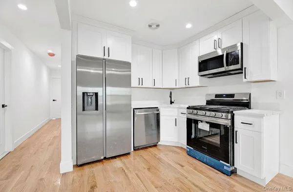 a kitchen with stainless steel appliances granite countertop a stove a refrigerator and a microwave