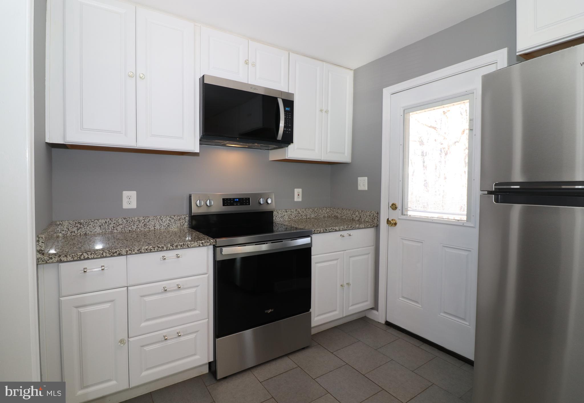 12551 Bristersburg Road Midland, VA 22728 - Photo 12 of 33 a kitchen with white cabinets stainless steel appliances and window