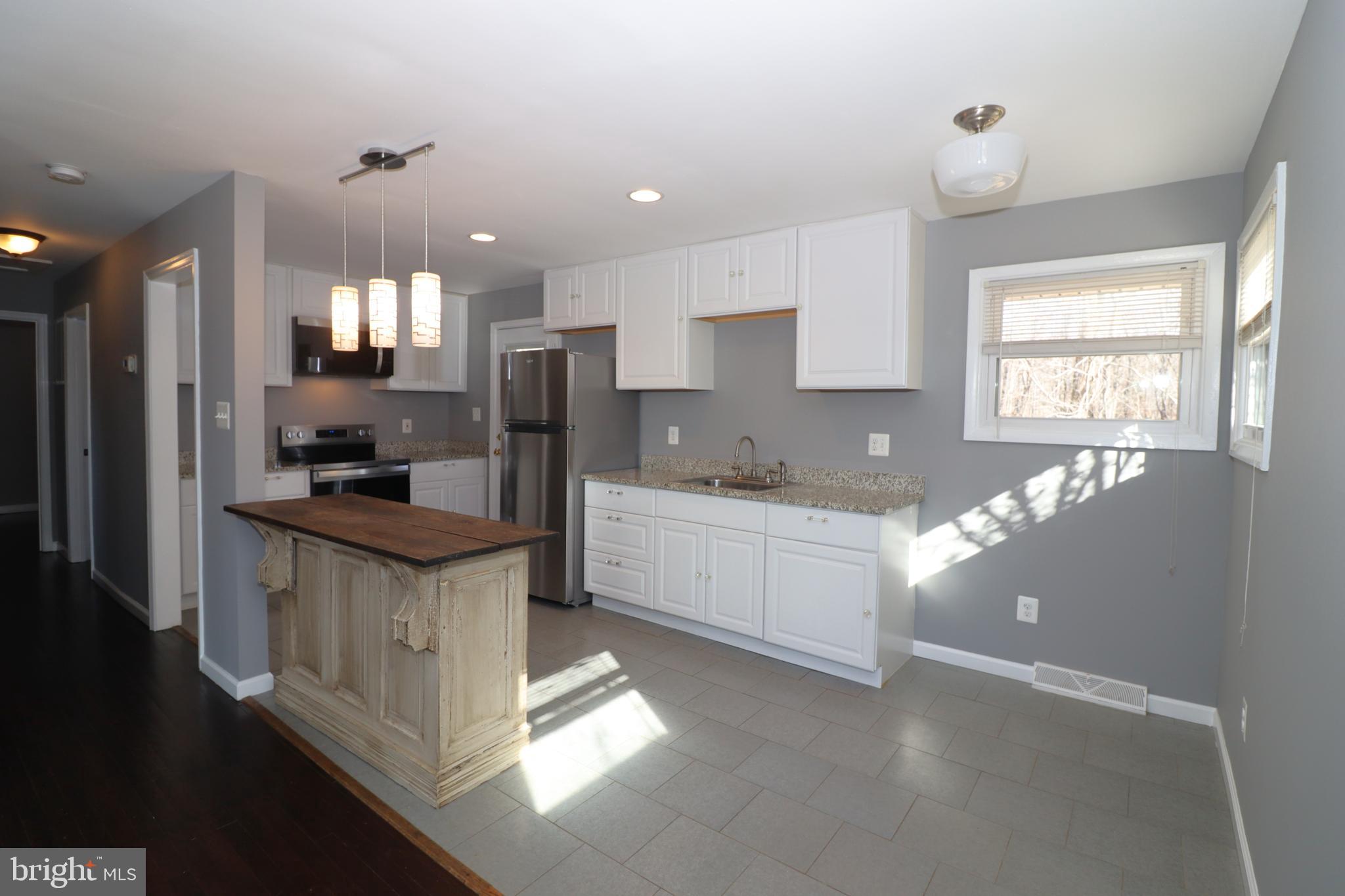 12551 Bristersburg Road Midland, VA 22728 - Photo 10 of 33 a kitchen with stainless steel appliances kitchen island granite countertop a sink refrigerator and cabinets