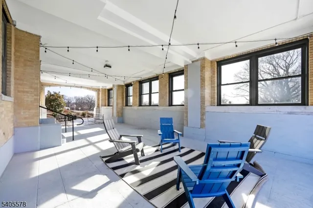 a view of a workspace with furniture a rug and a window