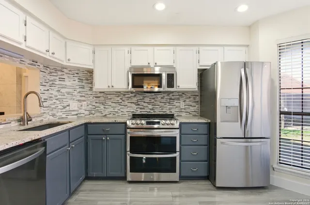a kitchen with granite countertop a refrigerator and a stove