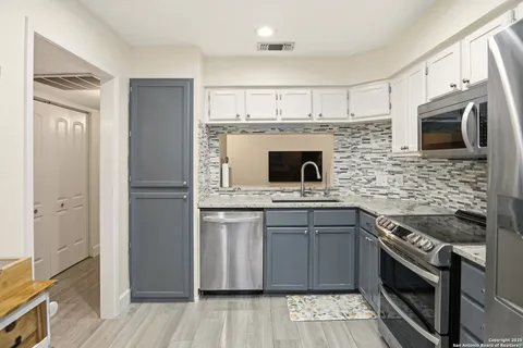 a kitchen with stainless steel appliances granite countertop a stove top oven microwave and refrigerator