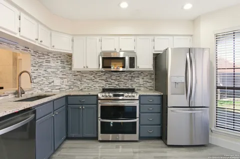 a kitchen with granite countertop a refrigerator and a stove