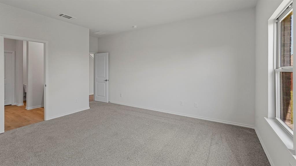 1627 Mantle Road Crandall, TX 75114 - Photo 22 of 40 Expansive interior space featuring light gray carpet, white painted walls, a large window, and multiple interior doorways