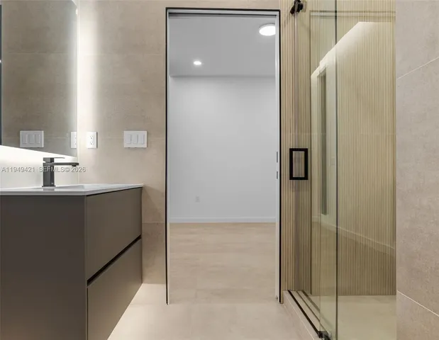 a bathroom with a sink a toilet a mirror and shower