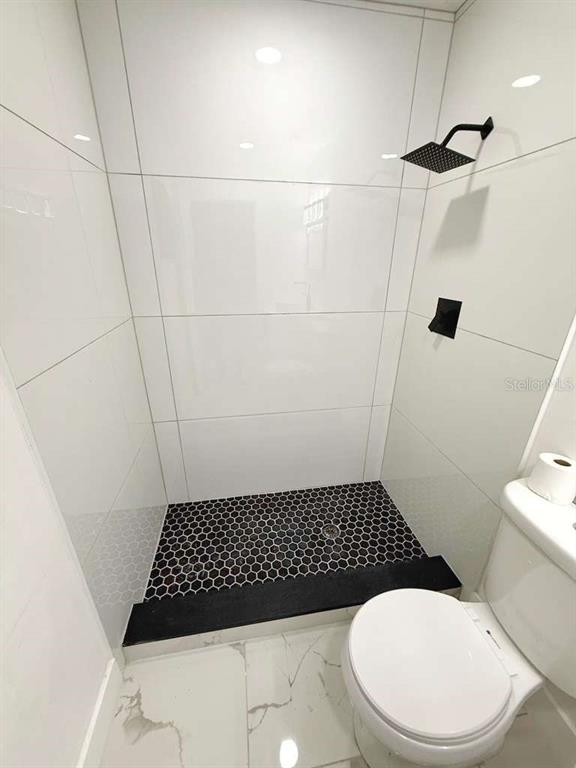 1048 Newbern Street Northeast Palm Bay, FL 32905 - Photo 14 of 29 a bathroom with a toilet and a shower