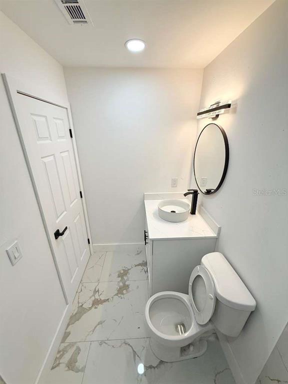 1048 Newbern Street Northeast Palm Bay, FL 32905 - Photo 16 of 29 a bathroom with a sink toilet and a mirror