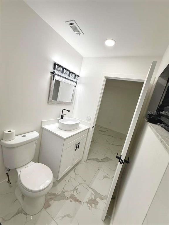 1048 Newbern Street Northeast Palm Bay, FL 32905 - Photo 25 of 29 a bathroom with a toilet sink and mirror