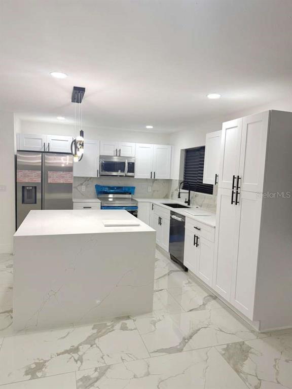 1048 Newbern Street Northeast Palm Bay, FL 32905 - Photo 6 of 29 a large kitchen with cabinets and stainless steel appliances