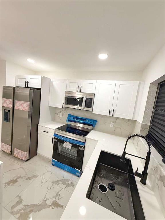 1048 Newbern Street Northeast Palm Bay, FL 32905 - Photo 7 of 29 a kitchen with furniture and a stove
