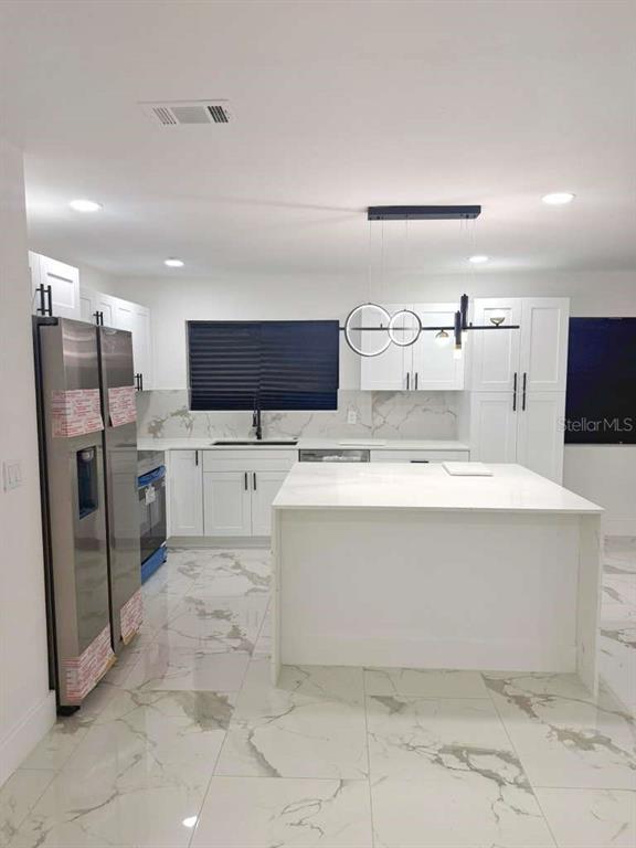 1048 Newbern Street Northeast Palm Bay, FL 32905 - Photo 9 of 29 a view living room with stainless steel appliances kitchen island sink refrigerator and stove