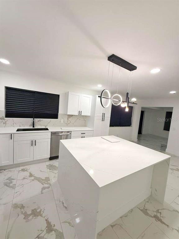 1048 Newbern Street Northeast Palm Bay, FL 32905 - Photo 10 of 29 a large white kitchen with sink a microwave a stove and a refrigerator